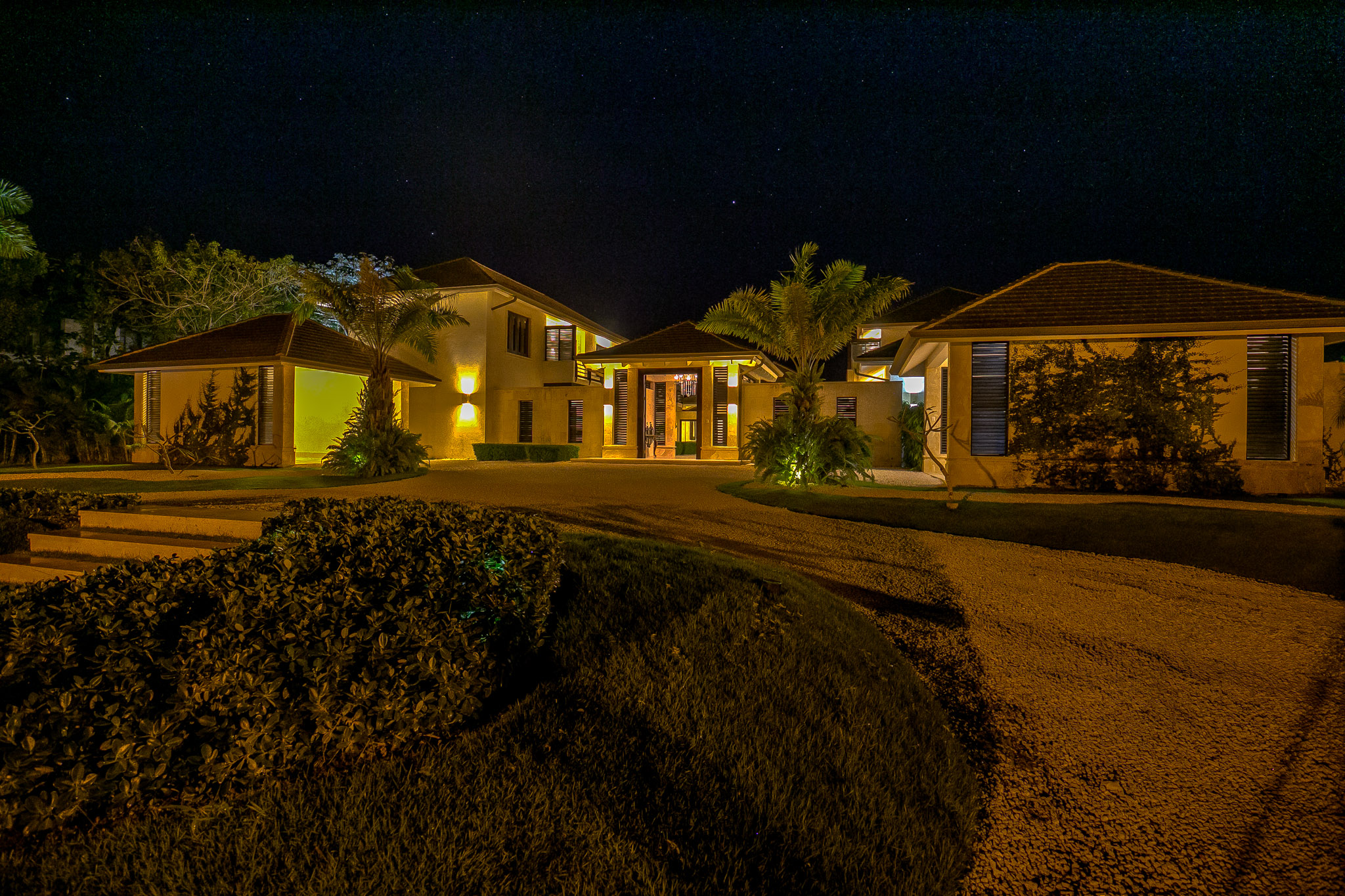 Casa de las Meninas illuminated at night with warm light on the entrance, stone surfaces and palm trees