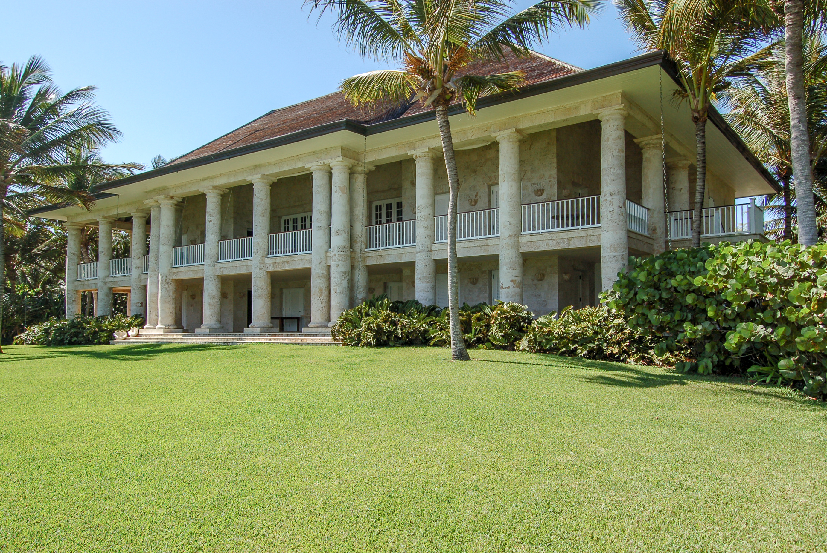Tall coral-stone columns rising across two levels of verandas at the Oscar de la Renta house